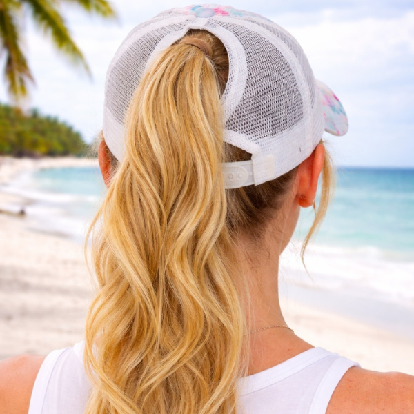 Back view of Beach Please tie dye trucker hat showing high ponytail opening on Florida beach &mdash; Crabby Mermaid