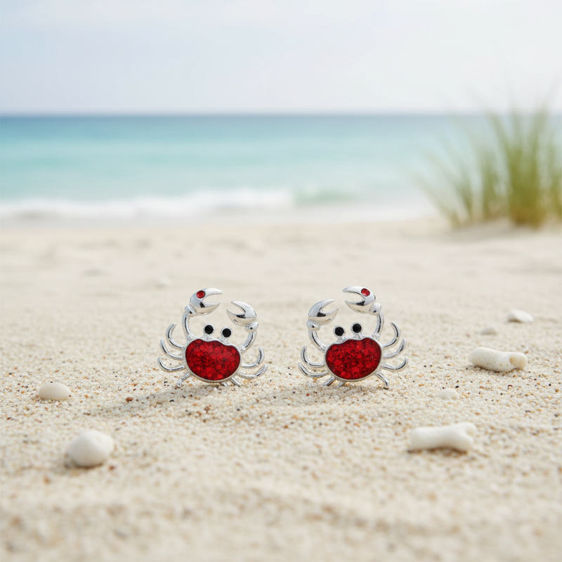 Red glitter crab stud earrings on Florida beach sand &mdash; coastal jewelry &mdash; Crabby Mermaid